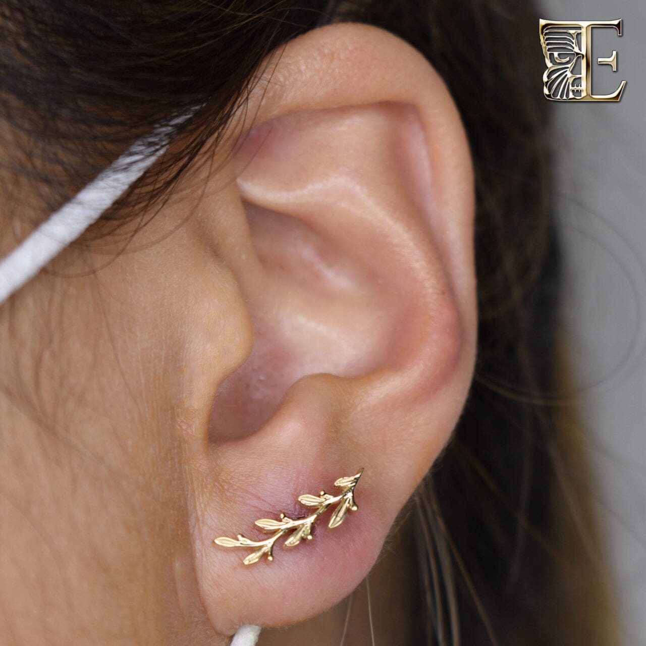 Earlobe pierced with a yellow gold threaded leaf end from BVLA