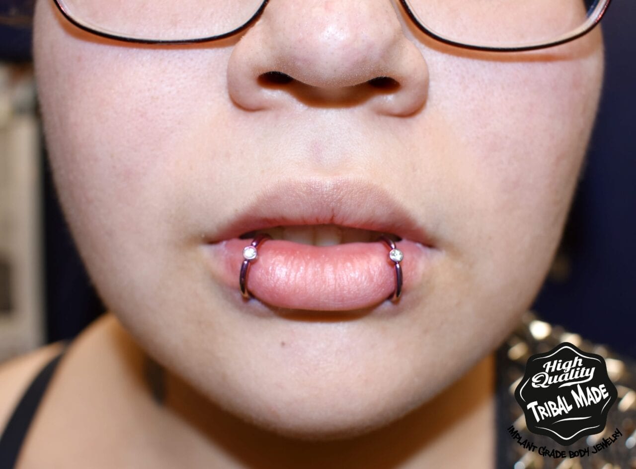 Double lip piercing with Tribal Expression 14g titanium captive bead rings anodized pink and bezel set CZ gem beads