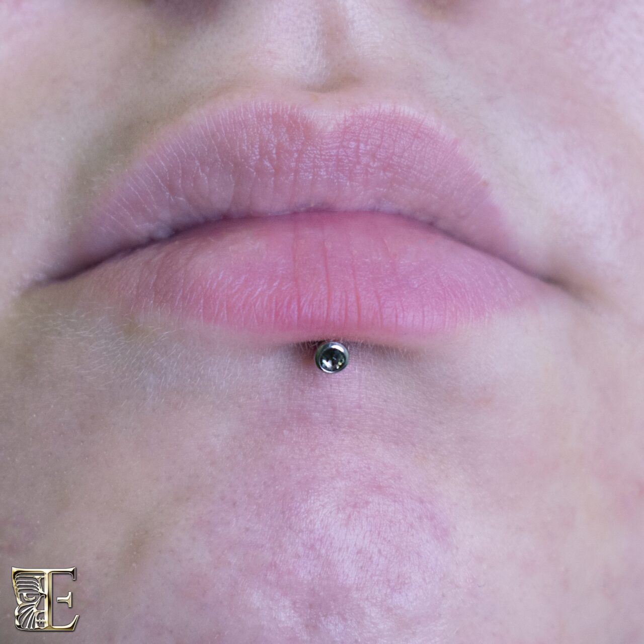 Lip piercing with a 16g threaded gem bead