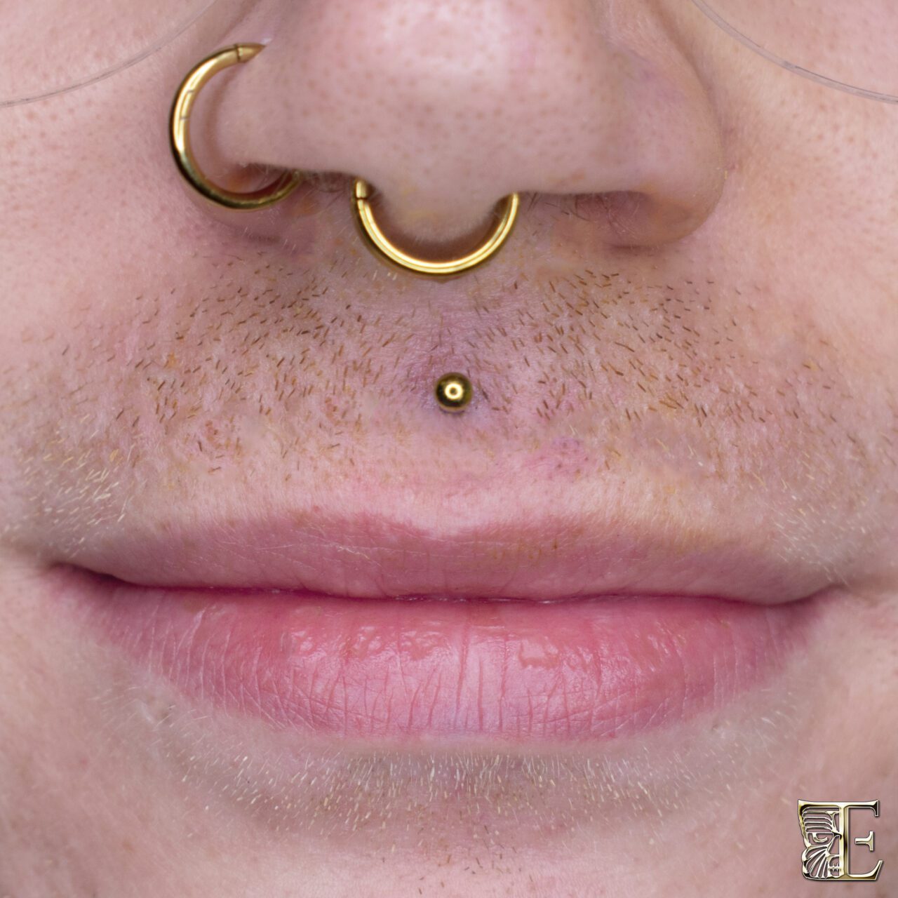 Forward-facing close-up of a male with a centered philtrum (medusa) piercing above the upper lip, featuring a minimalist implant-grade titanium stud made at Tribal Expression in Calgary